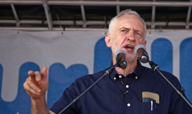 Image of Jeremy Corbyn speaking behind microphones at the NHS birthday demonstration.