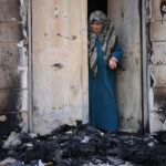 Nawal Domedi looks at the entrance to her house after it had been burned in a settler pogrom in the Palestinian town of Huwara, West Bank, February 28, 2023
