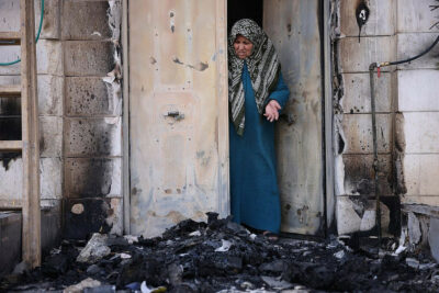 Nawal Domedi looks at the entrance to her house after it had been burned in a settler pogrom in the Palestinian town of Huwara, West Bank, February 28, 2023