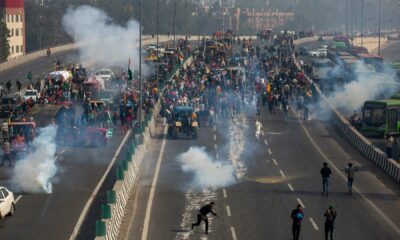 Protesting farmers hurl back tear gas shell as they march to the capital, breaking police barricades, during India's Republic Day celebrations in New Delhi on Jan 26.