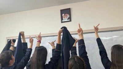 An image circulating on social media showing Iranian schoolgirls protesting a picture of the supreme leader. (Photo: Twitter via MERIP)