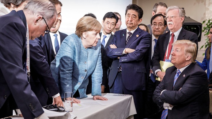 German Chancellor Angela Merkel speaks to U.S. President Donald Trump during the second day of the G7 meeting in Quebec, June 9, 2018