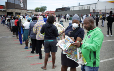 Shoppers queue outside a grocery store during a 21 day nationwide lockdown, aimed at limiting the spread of Covid-19 in Soweto, South Africa, March 30, 2020.